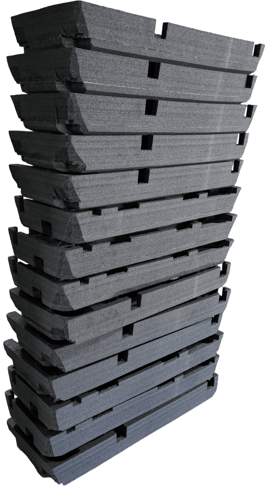 Stack of long custom-cut foam bases ready for case installation.