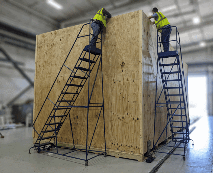 Vol Case team members building a large wooden crate around equipment