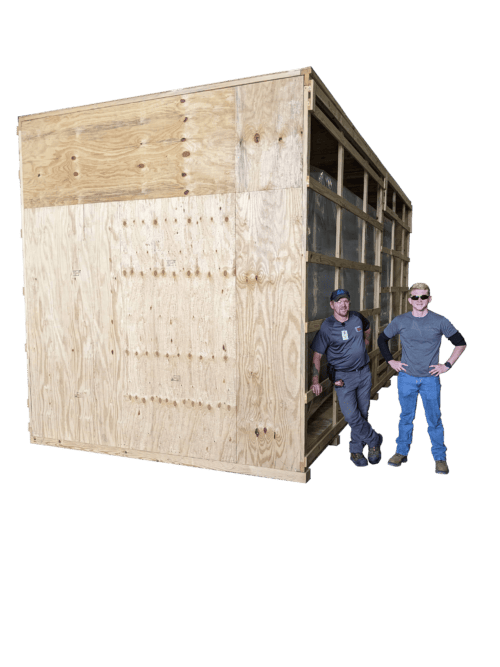 Two guys stand next to huge wood crate